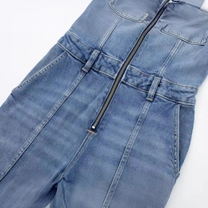 Combinaison longue en jean bleu pour femme avec fermeture zippée et poches poitrine
