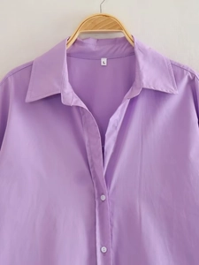Close-up of light purple poplin shirt collar with white buttons and size L label detail