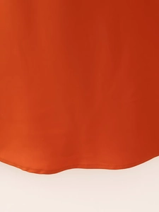 Nahaufnahme des orangefarbenen Satin-Saums mit Fokus auf die präzise Nahtverarbeitung