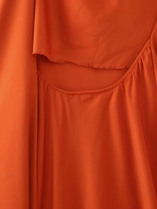 Detailansicht des orange-roten Satinkleids mit gerafftem Stoff und Ausschnitt-Ausschnitt