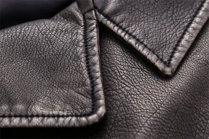 Macro shot of faux leather vest showing detailed collar stitching and grain texture