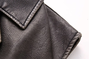 Detailed close-up of premium dark grey faux leather vest showing natural grain and fine stitching
