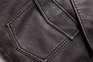 Close-up of the pebbled faux leather texture and double-stitched pocket on the vest