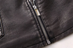 Detailed close-up of distressed faux leather texture and silver metal zipper on vest