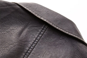 Detail of high-quality faux leather texture with precise double-stitching on the vest edge