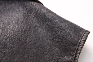 Detailed macro view of the premium dark brown faux leather texture with fine stitching edge