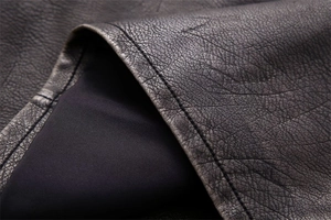Detailed macro view of high-quality faux leather texture and neat stitching on a summer vest