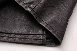 Detailed close-up of vintage faux leather texture and reinforced double stitching on the vest