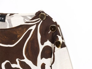 Detail of floral print top showing amber buttons on shoulder and cotton linen texture