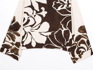 Close-up of floral print blouse showing linen texture and wide sleeve tailoring details