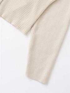 Detailed view of cream ribbed knit cardigan showing cuff texture and soft fabric seams