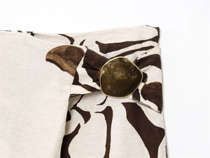 Detailed macro view of retro floral print fabric with amber resin and gold metal buckle