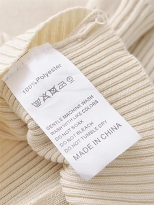 Detail of the washing label showing 100% polyester material and care instructions