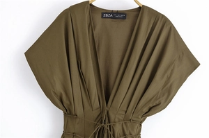 Dettaglio dell'abito midi verde militare con scollo a V, tessuto a pieghe e coulisse in vita