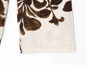 Detailed macro view of the breathable cotton linen texture and floral print on the pant cuff
