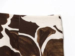 Detailed close-up of brown floral leaf print on linen-texture fabric waistband