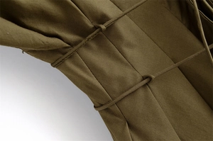 Dettaglio macro dell'abito a pieghe verde militare con tessuto in cotone e cuciture