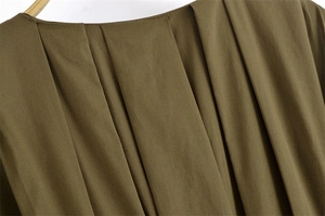 Dettaglio ravvicinato della scollatura a pieghe sull'abito midi verde oliva drappeggiato