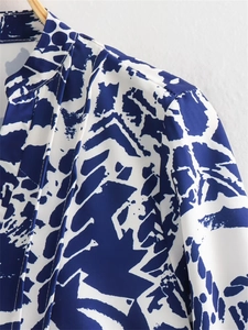 Détail du petit col montant et motif géométrique bleu et blanc sur le chemisier