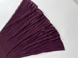 Detail of the pleated wine red fabric showing fine texture and rib knit craftsmanship