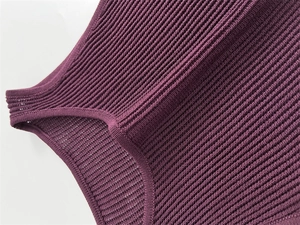 Detailed view of dark purple ribbed knit neckline and shoulder stitching on a summer dress