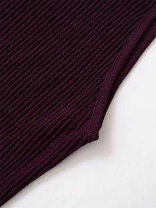 Detail shot of dark purple ribbed knit fabric showing fine vertical texture and stitching