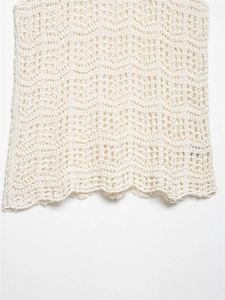 Detailansicht des Pointelle-Strickmusters und des Wellensaums eines cremefarbenen Tops