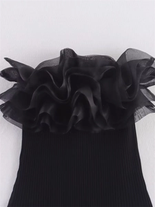 Détail du body noir à épaules dénudées avec volants en organza superposés et maille côtelée fine