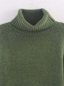 Detailed macro view of olive green knit fabric texture and high turtleneck collar design