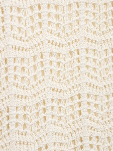 Nahaufnahme der cremeweißen Häkelware mit wellenförmigem Lochmuster und Textur