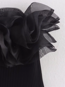 Détail de volants en organza noir superposés sur un body en maille côtelée