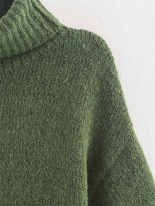 Detail of dark green chunky knit turtleneck sweater with fuzzy wool blend texture