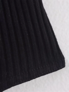 Détail du tissu côtelé noir montrant les coutures et la texture de qualité du body