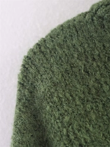 Close-up of grass green long-pile knit fabric showing fuzzy texture and mohair-like fibers