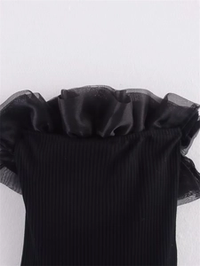 Détail de l'encolure à épaules dénudées avec volants en organza noir et maille côtelée douce