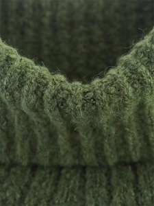 Detailed macro view of dark moss green ribbed knit texture with soft wool fibers