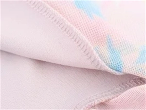 Nahaufnahme von rosa und hellblauem Batik-Stoff mit professioneller Overlock-Nahtverarbeitung