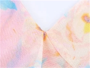 Detail des V-Ausschnitts mit bunten Batik-Mustern auf leichtem Mesh-Gewebe-Top