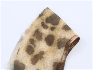 Makroaufnahme von durchsichtigem Mesh-Stoff mit Leopardenmuster und Overlock-Saum