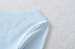 Detail view showing ribbed texture and neat stitching on light blue square neck top