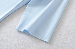 Macro detail of light blue cotton T-shirt showing fine ribbed cuff and knit texture