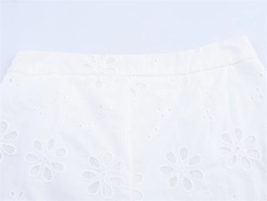 Close-up of intricate white floral lace embroidery on low-rise shorts waist detail
