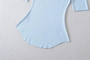 Detailed close-up of the curved hemline on a soft light blue cotton T-shirt for women
