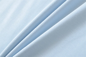 Macro shot of light blue cotton knit fabric texture with soft ribbed details and draping