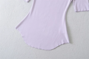 Detail view of a slim fit lavender top showing the curved hem and fine knit fabric texture