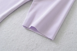 Macro shot of the ribbed knit texture and fine stitching on the light purple sleeve cuff