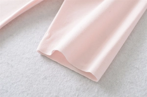 Close-up of light pink rib-knit cotton fabric detail on the short-sleeve T-shirt