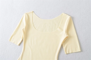 Detailed flat lay of a light yellow square neck t-shirt with fine knitted texture