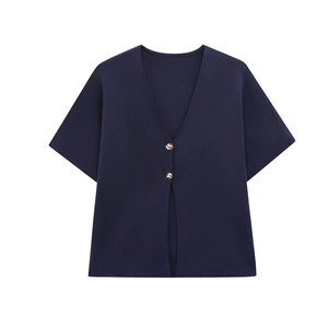 Détail d'un cardigan en tricot bleu marine avec col en V et deux boutons dorés