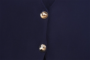 Détail rapproché d'un tricot bleu foncé avec d'élégants boutons en métal doré